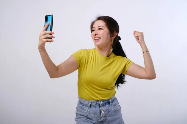 Photo Excited Happy Female Asian Looking Mobile Phone Screen Isolated — Stock Photo, Image