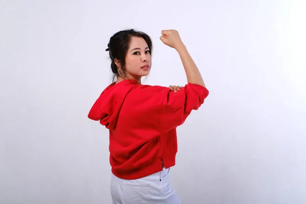 Usmívající Asijská Fena Červeným Svetrem Bílé Kalhoty Ukazující Silné Gesto — Stock fotografie