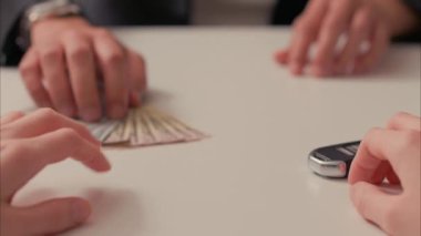 Latin Erkek, Beyaz El 'e Araba Anahtarı Karşılığında Para Veriyor, Sonra da Beyaz Kadın' la El sıkışır. ARRI Alexa ile ARRIRAW 'da 23.98 fps hızında çekildi ve QuickTime Apple ProRes 422 HQ ihraç edildi..