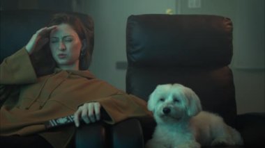 Güzel, genç, beyaz bir kadın köpekle televizyon izlerken baş ağrısı çekiyor. ARRI Alexa ile ArriRaw 'da çekildi ve QuickTime Apple ProRes 422 HQ ihraç edildi..