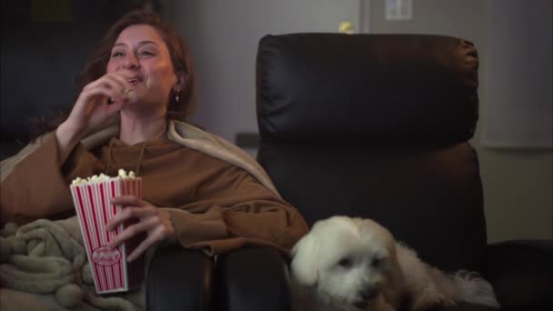 Beautiful Young Caucasian Woman Laughing Watching Television Eats Feeds Dog — Vídeos de Stock