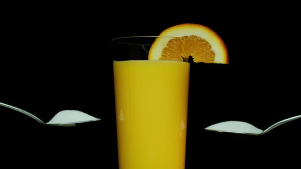 Twee Eetlepels Suiker Naast Glas Sinaasappelsap Met Sinaasappelschijfje Glas Schot — Stockvideo
