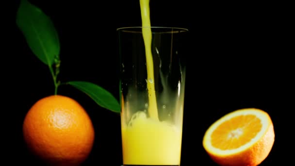 Häll Apelsinjuice Glas Bredvid Hela Apelsin Och Skivade Apelsin Skjuten — Stockvideo