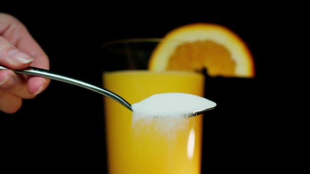 Spilling Tablespoon Sugar Front Glass Orange Juice Shot Arri Alexa — Stock Video