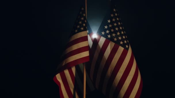 Deux Drapeaux Américains Debout Illuminés Dans Obscurité Panoramique Vers Haut — Video