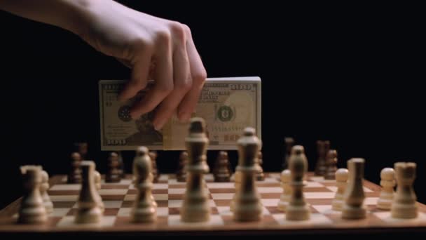 Kaukasische Frauenhand Legt Geldstapel Auf Rotierendes Schachbrett Aufnahme Mit Arri — Stockvideo