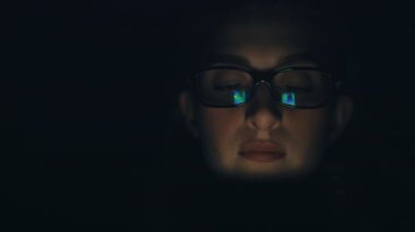 Tarafsız İfade 'de cep telefonu kullanan güzel beyaz kadın. Karanlık Arkaplan. ARRI Alexa ile 120 fps hızla ArriRaw 'da çekilmiş, 23.98 fps QuickTime Apple ProRes 422 HQ ihraç edilmiş..