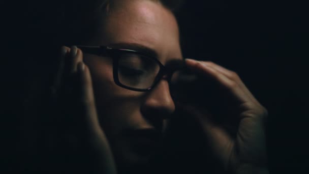 美しい若い白人女性は頭痛を取得します メガネを脱いで その後 こすり 頭を振る 暗い背景 120 FpsでArri Alexaで撮影し FpsをエクスポートQuicktime — ストック動画