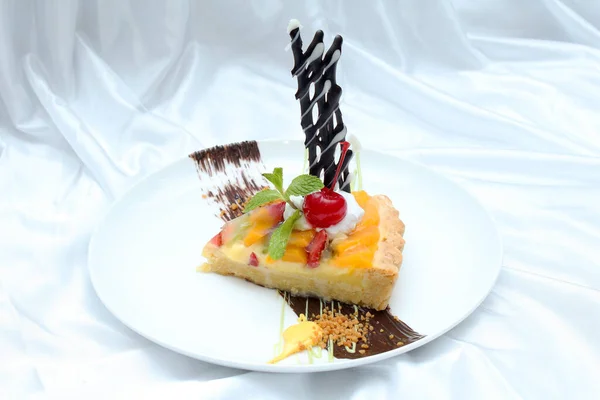 Sweet fruit pie or pie buah dessert on the plate. Delicious pastry sweets pie colorful cakes with fresh natural cherry and chocolate a baked dish that is usually made of pastry dough that contains vla with topping of various tropical fruits.