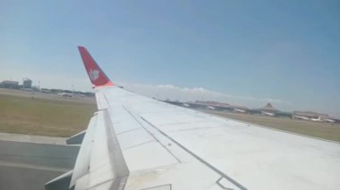 Surabaya, Doğu Java, Endonezya - 28 Ağustos 2023: Gündüz Surabaya 'daki Surabaya kentinin manzarası ile bir Aslan Hava Yolları uçağının havalanması durumu.