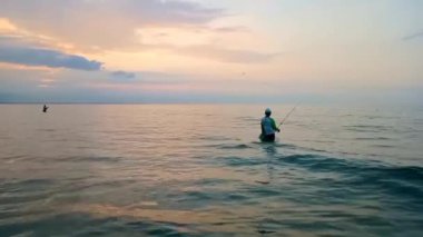 Güneş batarken, bir köylünün balık tuttuğu sahilde manzara.