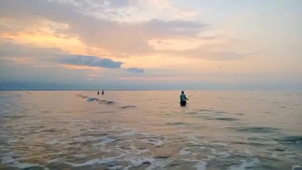 Θέα Στην Παραλία Έναν Χωριάτη Ψαρεύει Καθώς Ήλιος Αρχίζει Δύει — Αρχείο Βίντεο