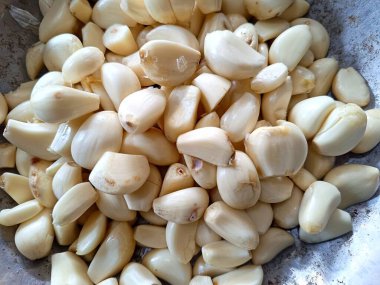 Baharat ve günlük yemek malzemelerinde kullanılan soyulmuş sarımsak yığını..