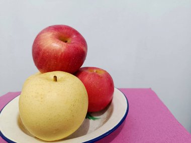 Kahvaltı için demir bir tabakta taze elmalar ve armutlar..