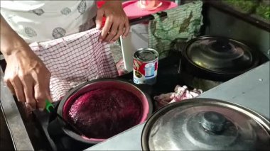 Bali, Endonezya - 22 Nisan 2025: Bir sokak yiyecek satıcısı, Nisan 2025 'te Kediri, Tabanan Bali' de kırmızı Terang Bulan keki veya Martabak Manis yapıyor. Bu aperatif gece yemek için mükemmel..