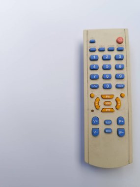 Kirli beyaz televizyon uzaktan kumandası. Düğmeler. Uzaktan kumanda cihazları kontrol ediliyor. Beyaz arkaplan.