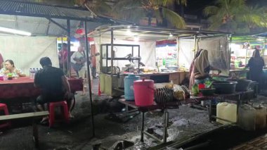 Bali, Endonezya - 25 Mayıs 2025: Tabanan, Bali 'deki gece pazarındaki etkinlik manzarası, sokak satıcılarının çeşitli yiyecek ve içecekler satması. Yemek yapmak, müşterilere hizmet etmek ve yemek yemek..