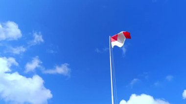 Endonezya ulusal bayrağı alçak açılı bir kameradan bulutlu mavi bir gökyüzü arka planına doğru dalgalanıyor. Kırmızı ve beyaz bayrak. Endonezya Cumhuriyeti Üniterlik Devleti.