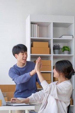 Küçük işletme KOBİ 'si kurun. Dizüstü bilgisayarı kullanan iki genç Asyalı girişimci online siparişleri kontrol ediyor ve müşteriler için toplanmaya hazırlanıyor. Başarılı KOBİ işi çevrimiçi kavramı...