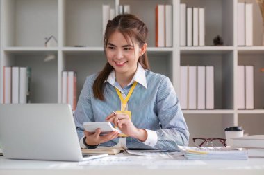 Hesap makinesi ve dizüstü bilgisayar kullanan iş kadını ofis ve iş geçmişinde, vergi, muhasebe, istatistik ve analitik araştırma kavramında ahşap masada finans yapıyor...