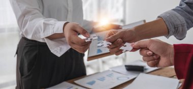 Group business people holding jigsaw puzzle together, Business man group are meeting together in the office, they are meeting the topic finance and financial management. Business management concept.