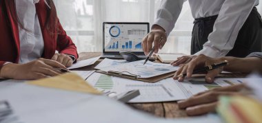 Business People Meeting using laptop computer,calculator,notebook,stock market chart paper for analysis Plans to improve quality next month. Conference Discussion Corporate Concept.