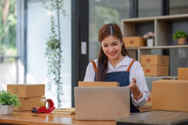 Küçük işletme girişimcisi KME, kutuda kumaş paketleyen Asyalı kadın. Portre genç Asyalı küçük işletme sahibi ev sahibi, çevrimiçi satış pazarlama teslimatı, KME e-ticaret tele pazarlama kavramı.