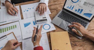 Business People Meeting using laptop computer,calculator,notebook,stock market chart paper for analysis Plans to improve quality next month. Conference Discussion Corporate Concept.