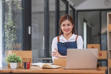 Küçük işletme girişimcisi KME, kutuda kumaş paketleyen Asyalı kadın. Portre genç Asyalı küçük işletme sahibi ev sahibi, çevrimiçi satış pazarlama teslimatı, KME e-ticaret tele pazarlama kavramı.