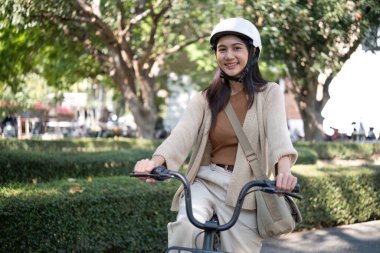 Asyalı iş kadını bisikletle sokaklarda mutlu mesut dolaşıyor..