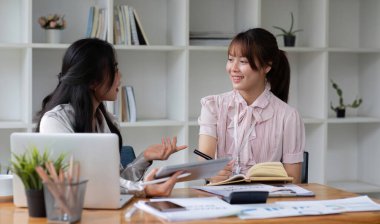 İki işadamı ofis işletmecisi proje stratejisini modern mali veri raporunda iş arkadaşlarıyla tartıştı.