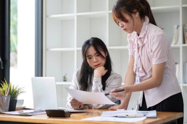 İki işadamı ofis işletmecisi proje stratejisini modern mali veri raporunda iş arkadaşlarıyla tartıştı.