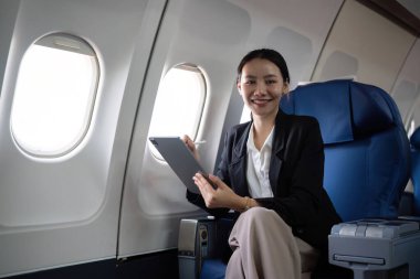 Genç Asyalı yöneticiler birinci sınıf. Dijital tabletler, dizüstü bilgisayarlar ve akıllı telefonlar ile birden fazla iş. Stil olarak seyahat et..