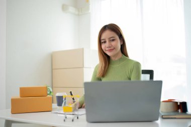 Business From Home Asian woman preparing package delivery box Shipping for shopping online. young start up small business owner at home online order.