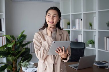 Ofiste tablet kullanan düşünceli bir iş kadını. Teknoloji, iş ve planlama kavramı.