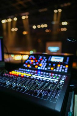 Bir gece kulübünün bulanık arkaplanıyla DJ karıştırma konsolu