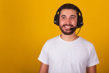 Kulaklığı ve mikrofonu olan mutlu Brezilyalı Latin Amerikalı adam, tele pazarlamacı, telefon desteği, çağrı desteği, tele pazarlama konsepti.