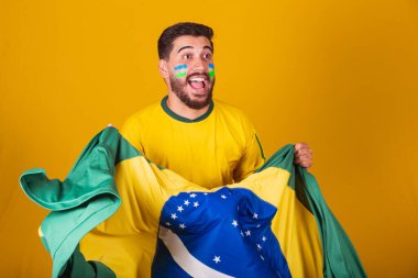 Brezilyalı adam, Latin Amerikalı, Brezilya için tezahürat yapıyor, 2022 Dünya Kupası 'nda, vatansever, milliyetçi, titreşimli Brezilya bayrağı, tezahürat, mutluluğun, sevincin ve kutlamanın sembolü, Brezilya bayrağıyla