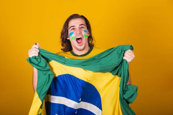 Brazilian man, latin american, cheering for brazil, in world cup 2022, Patriot, nationalist, Vibrating brazil flag, cheering and jumping, symbol of happiness, joy and celebration, with brazil flag