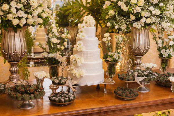 Υπέροχη Γαμήλια Τούρτα Που Περιβάλλεται Από Διακοσμήσεις Γλυκά Λουλούδια Και — Φωτογραφία Αρχείου