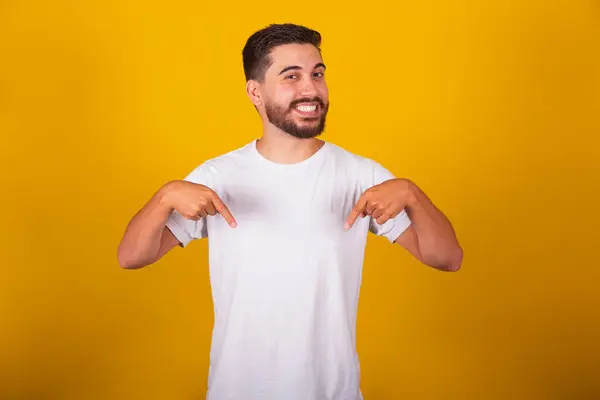 stock image Brazilian Latin American man, with fingers pointing here, pointing to himself, pointing to shirt, pointing to the center.