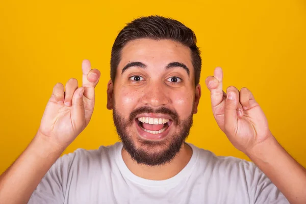 ブラジル系アメリカ人男性 指が交差し 宝くじ 黄色の背景のジェスチャー — ストック写真