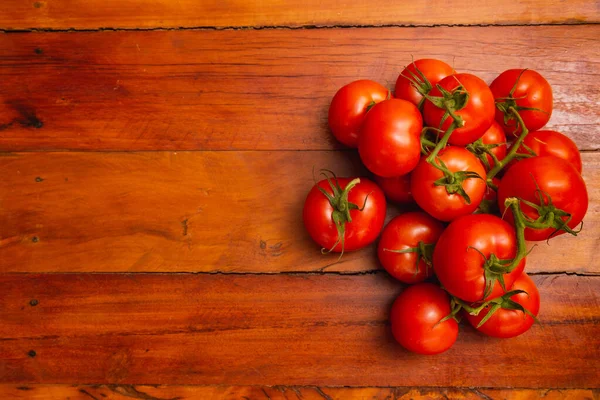 stock image Heap of tomatoes on wooden table, with negative space on left, t