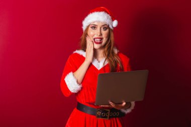 Güzel Brezilyalı kızıl saçlı kadın, Noel kıyafetleri giymiş, Noel Baba. Not defterini tutuyorum. İnanılmaz, inanılmaz..
