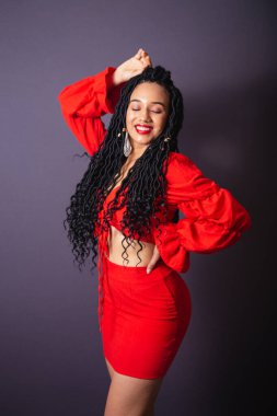 Kırmızılı güzel siyah Brezilyalı kadın. Yarı vücut portresi, gri sonsuzluk arkaplanı.