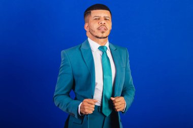 Brezilyalı siyah bir adam, takım elbise ve mavi kravat takmış. İş adamı. Elbiseyi tamir ediyorum.