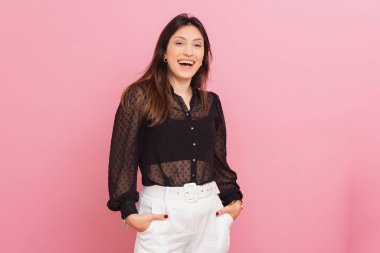 Güzel Brezilyalı Kafkasyalı Kadın, Pembe Arkaplan, Gülümseyen, Özgüvenli ve heybetli, Cebimde Eller, Fotoğraf İçin Poz.