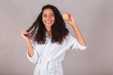 Bornoz ve havlu giymiş Brezilyalı siyahi kadın. Güzellik, cilt ve saç bakımı için vejetaryen ürünleri. sabun, spa, kişisel bakım. Refah.