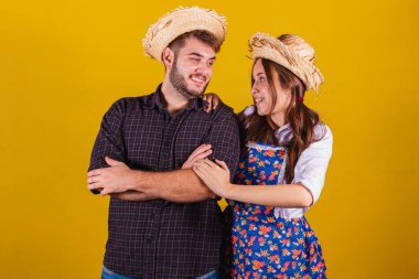 Festa Junina için tipik kıyafetler giyen güzel bir çift. Kollar çapraz, kendinden emin.