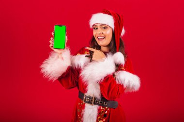 Noel kıyafetleri giymiş Brezilyalı kadın, Noel Baba. Krom renkli yeşil ekranlı akıllı telefonu tutmak.